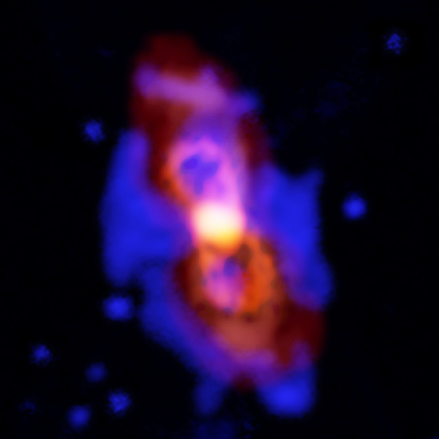 Composite image of CK Vul, the remains of a double-star collision. This impact launched radioactive molecules into space, as seen in the orange double-lobe structure at the center. This is an ALMA image of 27-aluminum monofluoride, but the rare isotopic version of AlF resides in the same region. The red, diffuse image is an ALMA image of the more extended dust in the region. The blue is optical hydrogen emission as seen by the Gemini observatory.