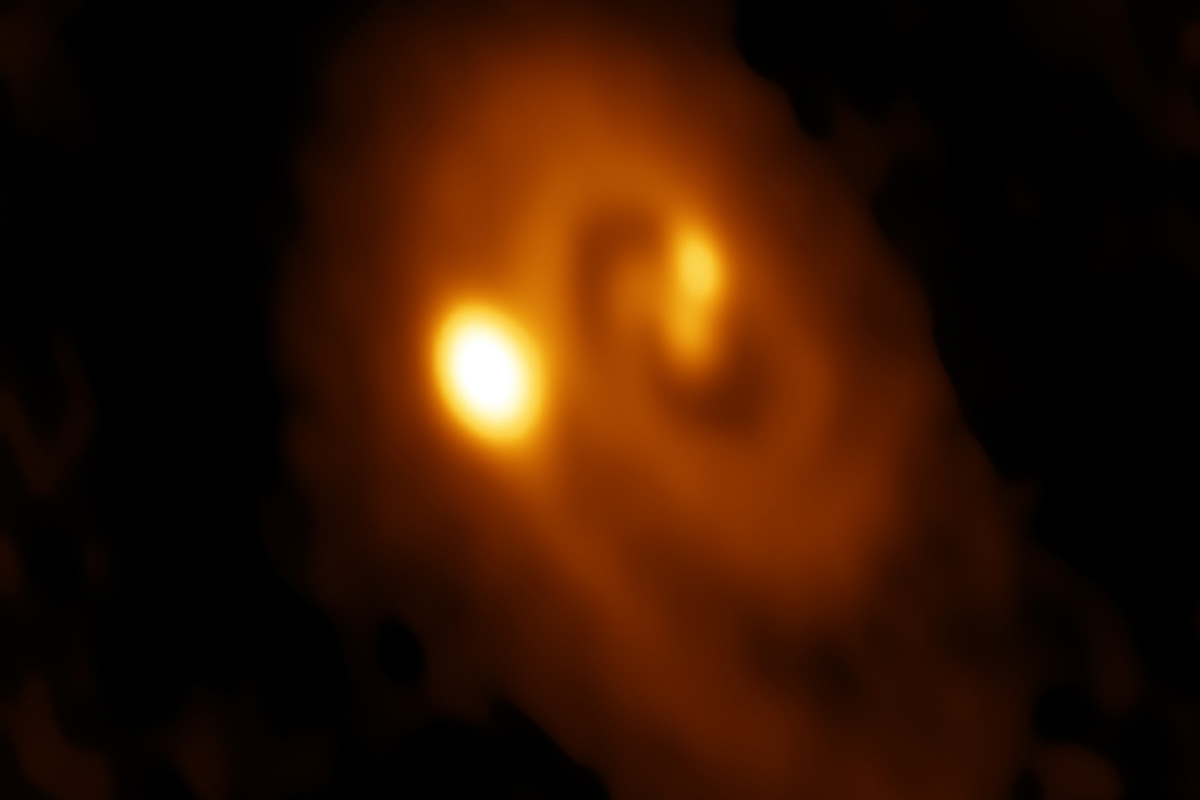 A radio image of a triple star system forming within a dusty disk in the Perseus molecular cloud obtained by the Atacama Large Millimeter/submillimeter Array (ALMA) in Chile.