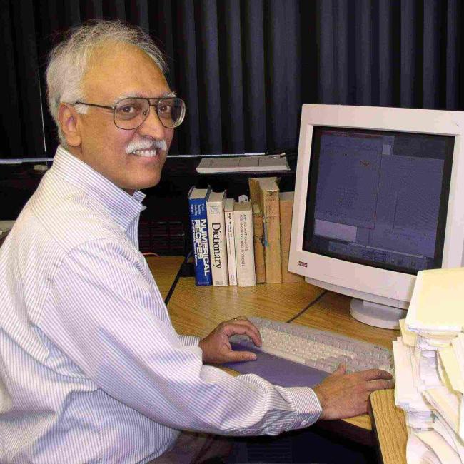 Ramesh Narayan works at his desk by a computer.